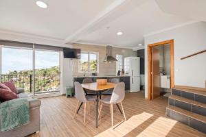 a kitchen and living room with a table and chairs at Casa da Feira - Located in a peaceful Calheta area with sea views in Calheta