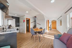 a kitchen and a living room with a table and chairs at Casa da Feira - Located in a peaceful Calheta area with sea views in Calheta