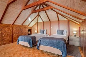 two beds in a room with wooden ceilings at Casa da Feira - Located in a peaceful Calheta area with sea views in Calheta