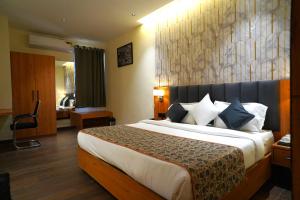 a bedroom with a large bed in a hotel room at Hotel Kunadan Courtyard in Gwalior