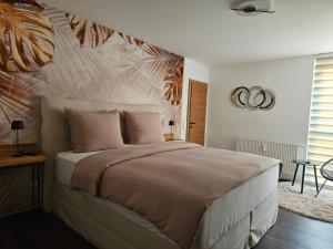 a bedroom with a large bed with a painting on the wall at Ferienwohnung Blick ins Grüne in Rossleithen +57 photos