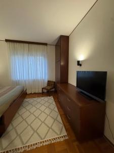 ein Schlafzimmer mit Bett und Flachbildfernseher in der Unterkunft La Grande Casa di Malpensa - B&B in Gallarate