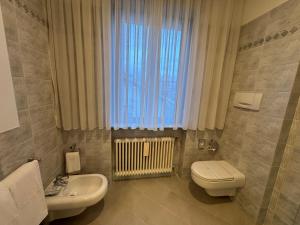 ein Badezimmer mit Toilette und Waschbecken und einem Fenster in der Unterkunft La Grande Casa di Malpensa - B&B in Gallarate + 70 Fotos
