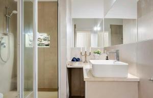 ein weißes Badezimmer mit Waschbecken und Dusche in der Unterkunft Spàzio apartments Sangiuliano in Catania + 25 Fotos