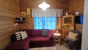 un soggiorno con un divano viola e una finestra di Ylläs Nilikammi a Ylläsjärvi