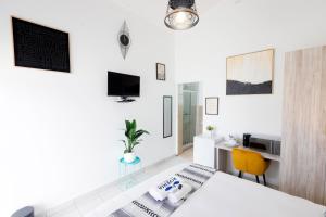 a white room with a bed and a desk at Riveria Guest Lodge and SPA in East London