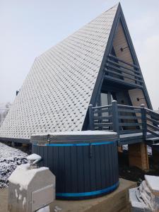 a house with a gambrel roof with a hot tub at Hill House in Slobozia-Măgura