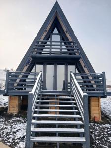 a frame house with a staircase in the snow at Hill House in Slobozia-Măgura