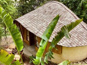 een klein huisje met een dak en wat palmbomen bij Les Terrasses Ceningan in Nusa Lembongan