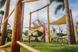 a swing in a park with palm trees at Lagoon Paradise in Fortim