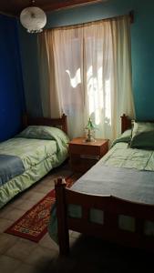 una camera da letto con due letti e una finestra di Alojamiento en Malargue a Malargüe