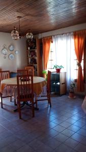 una sala da pranzo con tavolo, sedie e finestre di Alojamiento en Malargue a Malargüe