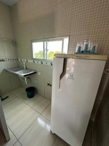 een kleine keuken met een koelkast en een wastafel bij Quarto privativo com sala e tv em Villa Hostel in Pedro II