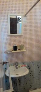 a bathroom with a sink and a mirror at Micaval Residential in São Tomé