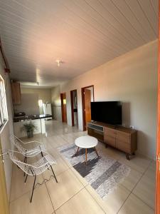 een woonkamer met een tv en een tafel en stoelen bij Quarto privativo com sala e tv em Villa Hostel in Pedro II