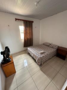 een slaapkamer met een bed, een tafel en een raam bij Quarto privativo com sala e tv em Villa Hostel in Pedro II