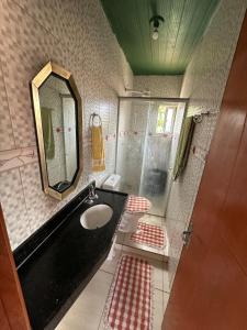 een badkamer met een wastafel en een spiegel en een toilet bij Quarto privativo com sala e tv em Villa Hostel in Pedro II