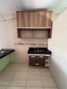 een kleine keuken met een wastafel in de kamer bij Quarto privativo com sala e tv em Villa Hostel in Pedro II