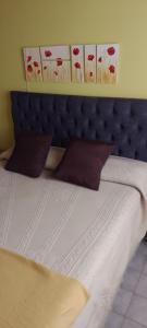 una camera da letto con un letto con testiera blu di Alojamiento en Malargue a Malargüe