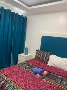 a bedroom with a bed with blue curtains at Birch tower Condominium in Manila