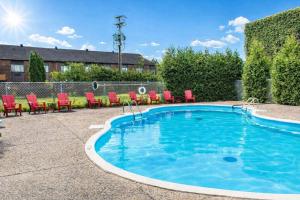a swimming pool with red chairs next to at Quality Inn & Suites in Gatineau