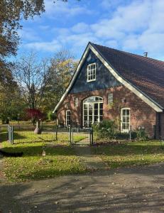 een stenen huis met een zwart dak bij Huize Kroezzz in Goor