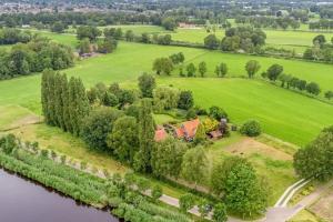 een luchtzicht op een huis op een heuvel naast een rivier bij Huize Kroezzz in Goor +7 foto's