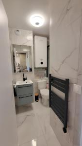 een witte badkamer met een wastafel en een toilet bij Cozy Apartment Bicetre in Le Kremlin-Bicêtre