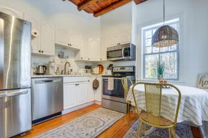 a kitchen with white cabinets and a table and chairs at Charming Jaffrey Cottage with Deck and Grill! in Jaffrey