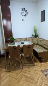 een tafel en stoelen in een woonkamer met een bank bij apartman Stojković in Petrovac na Mlavi