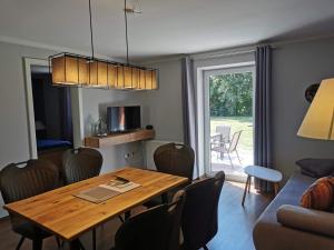 een woonkamer met een houten tafel en een eetkamer bij 07 Birkenhain - Hof Wiesengrund in Parchtitz