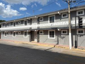 ein Wohnhaus mit weißen Balkonen an einer Straße in der Unterkunft Monet Hotel Motul in Motul de Felipe Carrillo Puerto