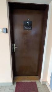 een bruine deur met een bord erop bij apartman Stojković in Petrovac na Mlavi