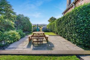 a picnic table in a garden next to a hedge at 1 Bed in Errol oc-s33022 in Errol