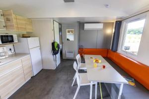 a small kitchen with a white table and chairs at ZEcamping 5 étoiles familial animaux acceptés in Sainte-Catherine-de-Fierbois