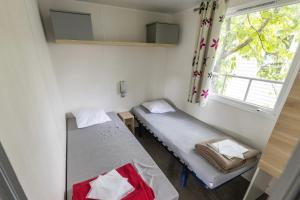 En eller flere senge i et værelse på Camping 5 étoiles - Parc aquatique - ccbedee