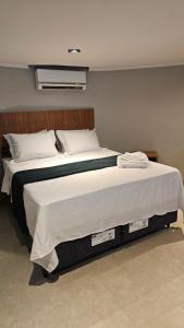 une chambre avec un grand lit avec des draps blancs dans l'établissement Chalés Feliz Boipeba, à Cairu