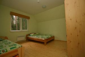 a bedroom with a bed and a window at Guest House Gaujaspriedes in Gauja