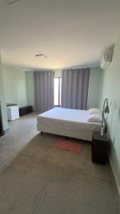 een slaapkamer met een wit bed en een lamp bij Esquina Da Mata in Pirenópolis +29 foto's