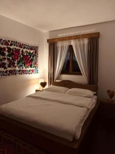a bedroom with a large bed with a window at Cabana Elena in Borşa +10 photos