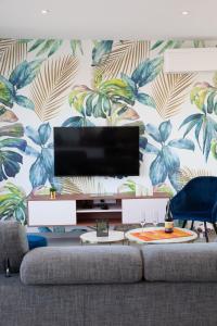 a living room with a couch and a wall mural at Villa ELISA Piscine Intérieure partagée chauffée à 29 degrés à 100m de la plage in Sibiril