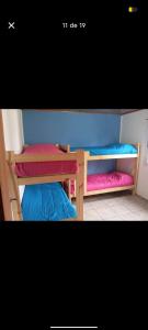 two bunk beds with different colored sheets on them at El Atardecer in Villa Giardino