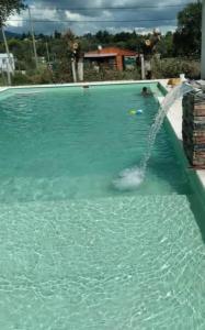 a pool with a water fountain in a swimming pool at El Atardecer in Villa Giardino