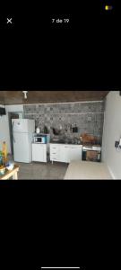 a kitchen with white appliances and a brick wall at El Atardecer in Villa Giardino +7 photos