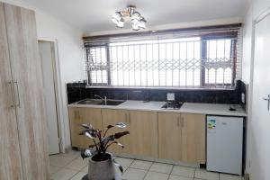 a kitchen with a sink and a window at Riveria Guest Lodge and SPA in East London