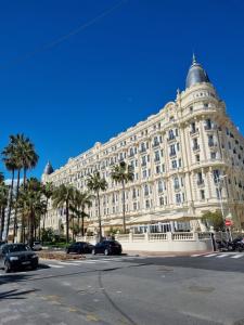 een groot wit gebouw met palmbomen ervoor bij Palais Selvosa in Cannes