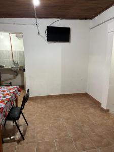 a room with a table and a tv on a wall at Alojamiento Paz in Esquina