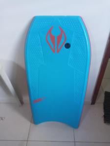 a blue surfboard sitting on top of a floor at Quarto suite in Florianópolis