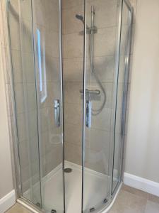 een douche met een glazen omhulsel in een badkamer bij Guests house in Sligo