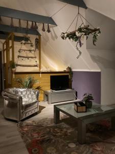 een woonkamer met een bank en een tv bij Appartementen Elzentuin in Oud-Beijerland